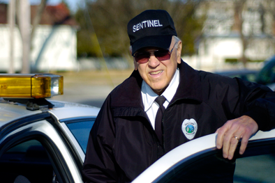 Sentinel Burrus in uniform stepping into police vehicle