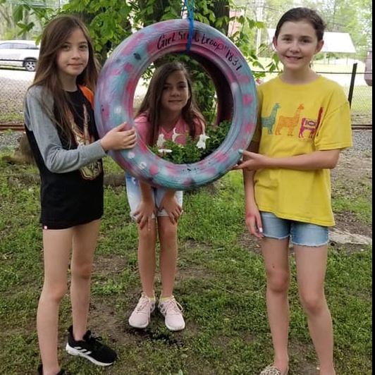 girl scouts in train yard with tire art project